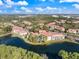An aerial view of condos that are near a lake. Lots of green trees surround the area of the community at 5552 Bentgrass Dr # 7-116, Sarasota, FL 34235
