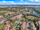 Aerial view of a community featuring a pool and nearby lake with lush greenery and palm trees at 5552 Bentgrass Dr # 7-116, Sarasota, FL 34235