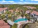 Aerial view of a community featuring a pool area with lounge chairs, pergolas, and palm trees at 5552 Bentgrass Dr # 7-116, Sarasota, FL 34235