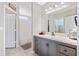 Well-lit bathroom featuring a gray vanity with a granite countertop and a shower with white curtain at 5552 Bentgrass Dr # 7-116, Sarasota, FL 34235