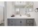 Bright bathroom featuring gray vanity with granite countertop and a large mirror at 5552 Bentgrass Dr # 7-116, Sarasota, FL 34235