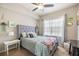 Bright bedroom featuring a plush gray bed, large window, and charming decor, creating a cozy atmosphere at 5552 Bentgrass Dr # 7-116, Sarasota, FL 34235