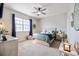 Cozy bedroom featuring a ceiling fan, large window with curtains and warm neutral carpet at 5552 Bentgrass Dr # 7-116, Sarasota, FL 34235