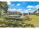 Beautiful community view featuring a pond with fountain, lush landscaping and multi-Gathering residences under a sunny, partly cloudy sky at 5552 Bentgrass Dr # 7-116, Sarasota, FL 34235