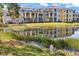 Exterior view of the community buildings reflecting in a pond surrounded by lush greenery at 5552 Bentgrass Dr # 7-116, Sarasota, FL 34235