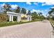 Welcome to Las Palmas Luxury Condominiums entrance with a decorative pergola and lush landscaping leading into the community at 5552 Bentgrass Dr # 7-116, Sarasota, FL 34235