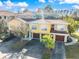 Exterior elevation of the townhome featuring a two-car garage, beautiful trees, and a paved driveway at 5552 Bentgrass Dr # 7-116, Sarasota, FL 34235