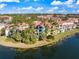 Beautiful exterior view of a multi-story condo building with red tile roofs and lush tropical landscaping along the waterfront at 5552 Bentgrass Dr # 7-116, Sarasota, FL 34235