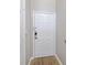 A white front door with a smart lock and a peephole sits between a white wall and a white doorframe at 5552 Bentgrass Dr # 7-116, Sarasota, FL 34235