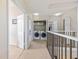 Hallway with laundry closet featuring updated washer and dryer, open to bright living space at 5552 Bentgrass Dr # 7-116, Sarasota, FL 34235