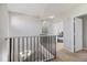 Second floor hallway with neutral paint, carpeting, and dark railing overlooking the entryway at 5552 Bentgrass Dr # 7-116, Sarasota, FL 34235