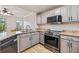 Modern kitchen with granite countertops, stainless steel appliances, and grey cabinetry at 5552 Bentgrass Dr # 7-116, Sarasota, FL 34235