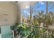 A screened porch featuring a chair, tropical plants and trees in view at 5552 Bentgrass Dr # 7-116, Sarasota, FL 34235
