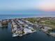 An aerial shot highlights a waterfront home with a pool, dock, and stunning views of the ocean at 624 N Point Dr, Holmes Beach, FL 34217