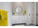 Spacious bathroom featuring a round mirror, quartz countertops, and white cabinetry at 624 N Point Dr, Holmes Beach, FL 34217