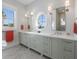 Bright bathroom featuring double vanity, herringbone floors, a porthole window, and stylish fixtures at 624 N Point Dr, Holmes Beach, FL 34217