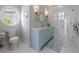Elegant bathroom with hexagon tile, blue vanity, and glass shower at 624 N Point Dr, Holmes Beach, FL 34217