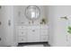 Clean bathroom featuring a round mirror, quartz countertops, and white cabinetry at 624 N Point Dr, Holmes Beach, FL 34217