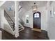 Elegant entryway featuring a dark wood door, chandelier, staircase with iron railing, and dark hardwood floors at 624 N Point Dr, Holmes Beach, FL 34217