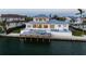 Elegant waterfront home with a private pool, dock, and outdoor lounge area for luxurious coastal living at 624 N Point Dr, Holmes Beach, FL 34217