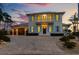 Elegant two-story home featuring a brick driveway, a balcony, and beautiful, light blue shutters at 624 N Point Dr, Holmes Beach, FL 34217