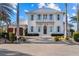 Beautiful two-story home features a brick driveway, a balcony, and charming, light blue shutters at 624 N Point Dr, Holmes Beach, FL 34217