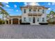 Charming two-story home featuring a brick driveway, a balcony, and beautiful, light blue shutters at 624 N Point Dr, Holmes Beach, FL 34217