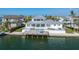 Stunning view of the rear of a waterfront home showcasing a pool, patio and dock at 624 N Point Dr, Holmes Beach, FL 34217