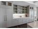 Kitchen with custom cabinets, open shelving, white subway tile backsplash, and stainless steel appliances at 624 N Point Dr, Holmes Beach, FL 34217