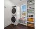 Laundry room with stacked washer and dryer, window, and custom shelving for storage at 624 N Point Dr, Holmes Beach, FL 34217