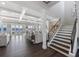 Bright, open living room with water views, coffered ceilings, hardwood floors, and a staircase to the second floor at 624 N Point Dr, Holmes Beach, FL 34217