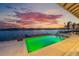 Waterfront pool with dock and outdoor seating offers beautiful sunset views over the bay at 624 N Point Dr, Holmes Beach, FL 34217