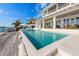 Beautiful waterfront pool with lounge chairs, patio seating, and a private dock at 624 N Point Dr, Holmes Beach, FL 34217