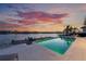 Waterfront pool with dock and outdoor seating offers beautiful sunset views over the bay at 624 N Point Dr, Holmes Beach, FL 34217