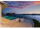 Waterfront pool with dock and outdoor seating provides beautiful sunset views over the bay at 624 N Point Dr, Holmes Beach, FL 34217