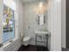Powder room featuring an accent wall, modern fixtures, dark floors, and a window for natural light at 624 N Point Dr, Holmes Beach, FL 34217