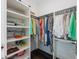 Walk-in closet with custom shelves, hanging rods, and organized clothing at 624 N Point Dr, Holmes Beach, FL 34217