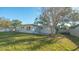 Spacious backyard with a large lawn and shade from a mature tree at 7272 Cass Cir, Sarasota, FL 34231