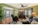 Comfortable green living room with a ceiling fan and view to an outdoor patio through french doors at 7272 Cass Cir, Sarasota, FL 34231