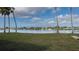 Backyard view of lake bordered by manicured lawn and palm trees creates a tranquil and picturesque setting at 8449 Imperial Cir, Palmetto, FL 34221