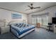 Bedroom featuring blue carpet, a ceiling fan, a window with blinds, and white wicker furnishings at 8449 Imperial Cir, Palmetto, FL 34221