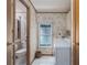 Cozy laundry room features a front-load washer, patterned wallpaper, and ample natural light through the window at 8449 Imperial Cir, Palmetto, FL 34221