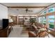Bright living room featuring many windows with a waterfront view, ceiling fan, and wicker furnishings at 8449 Imperial Cir, Palmetto, FL 34221