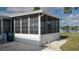 Enclosed screened patio with large windows provides serene outdoor living with views of landscaped yard and lake at 8449 Imperial Cir, Palmetto, FL 34221