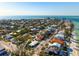 An aerial of a home surrounded by neighborhood homes, a lovely beach, and clear blue water at 912 N Shore Dr, Anna Maria, FL 34216