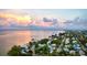 Aerial view of residential neighborhood near a calm bay at sunset, showcasing waterfront living at 912 N Shore Dr, Anna Maria, FL 34216