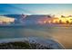 Scenic aerial view of a beach and ocean with a dramatic sky during sunset, creating a picturesque scene at 912 N Shore Dr, Anna Maria, FL 34216