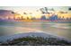 Panoramic view of a sandy beach and ocean coastline with a colorful sunset sky in the background at 912 N Shore Dr, Anna Maria, FL 34216