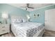 Comfortable bedroom with teal walls, large bed, ceiling fan and natural lighting at 912 N Shore Dr, Anna Maria, FL 34216