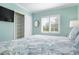 Comfortable bedroom with teal walls, large bed, ceiling fan, and closet with sliding doors at 912 N Shore Dr, Anna Maria, FL 34216